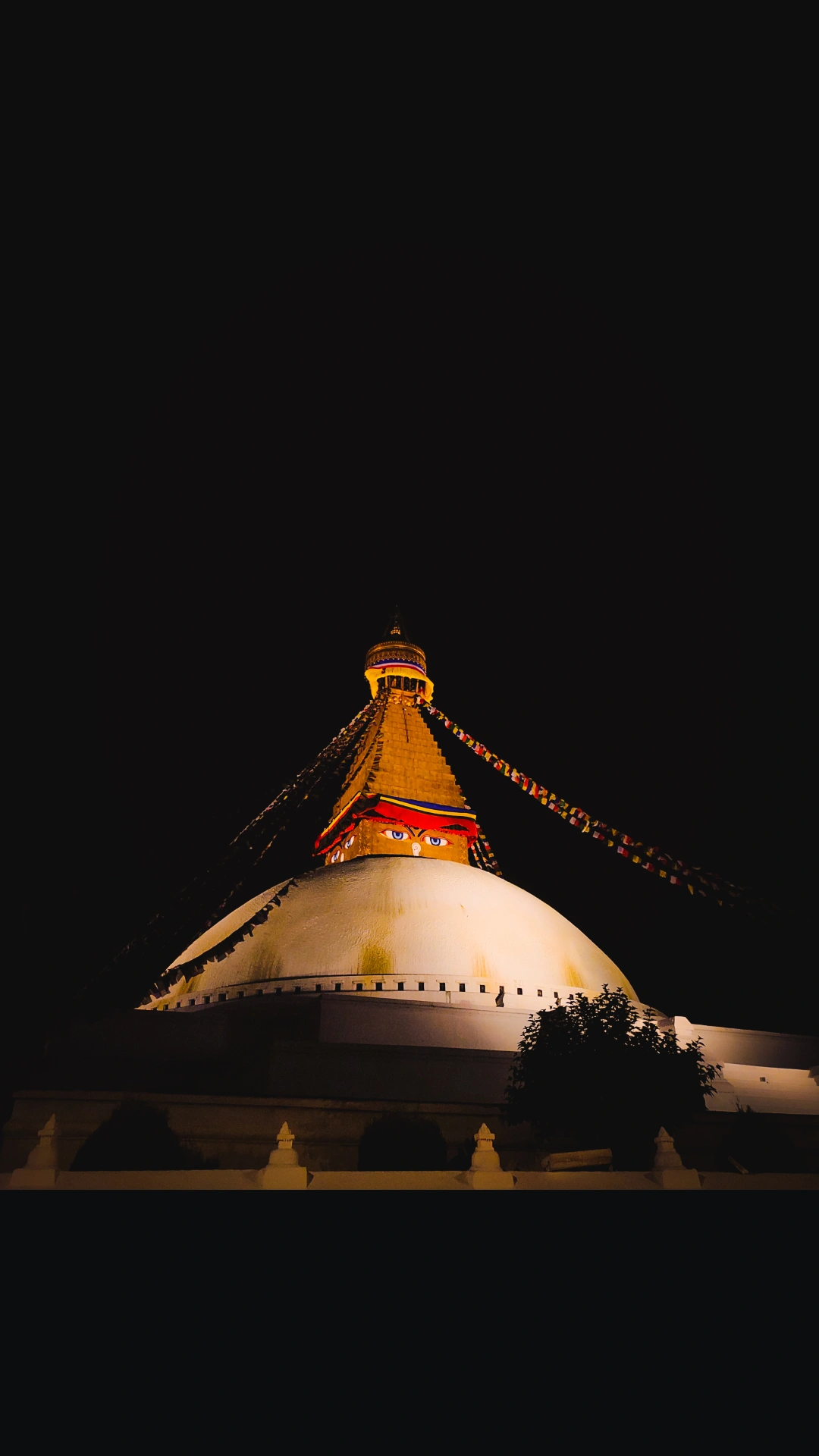 Boudhanath Stupa glowing against the night sky