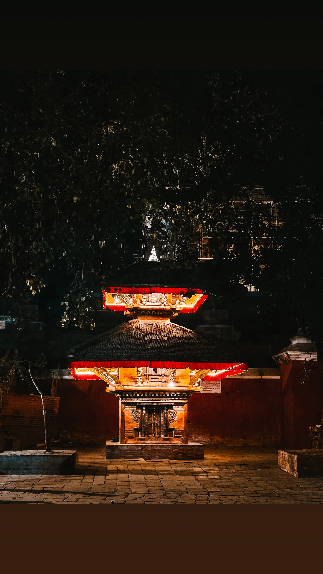 Quiet temple courtyard glowing at night